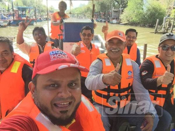 Mohd Ridzwan berswafoto bersama ahli majlis Daerah Yan ketika lawatan ke Pulau Bidan, semalam. 