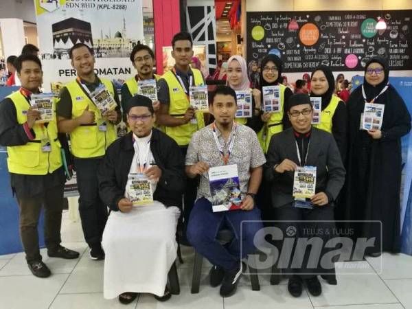 Abdul Rahim (duduk, tengah) mempromosikan tawaran pakej umrah dan destinasi pelancongan popular lain ditawarkan Busyra Holidays Sdn Bhd sambil diiringi kakitangan syarikatnya hari ini.