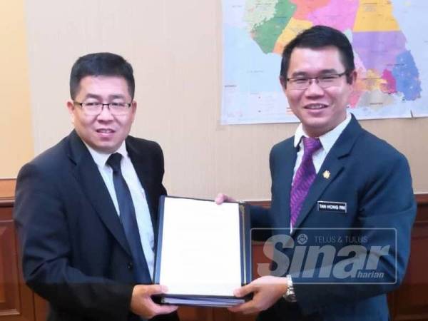 Hong Pin (kiri) menyerahkan nota serah terima tugas kepada Exco Kerajaan Tempatan negeri yang baharu, Tan Cheng Choon di pejabatnya, hari ini.