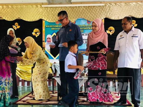 Abdul Rahman (tengah) menyerahkan sumbangan kepada pelajar di SK Permatang Buluh, di sini, kelmarin.