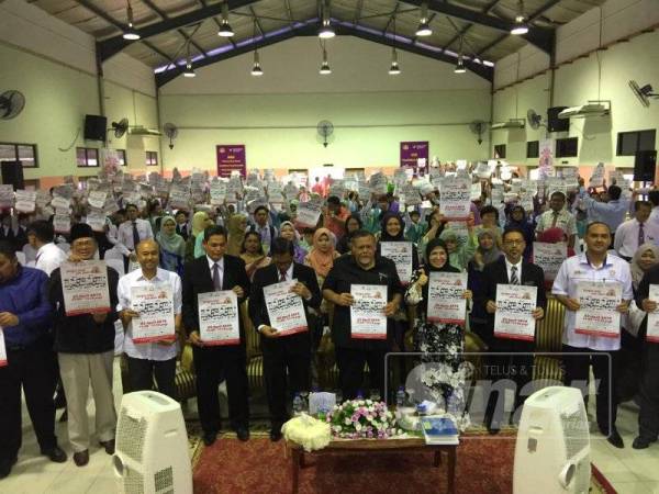 Exco Pendidikan, Sumber Manusia, Sains dan Teknologi negeri, Aminolhuda Hassan bersama warga SK Sri Tebrau mengangkat poster kempen Jom Memaca Bersama Selama 10 Minit.