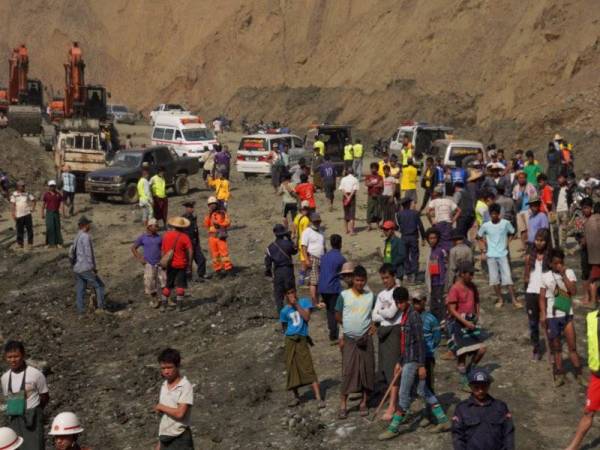 Anggota penyelamat dan orang ramai berada di lokasi tanah runtuh di wilayah Hpakant yang dilaporkan meragut lebih 50 nyawa. - Foto AFP
