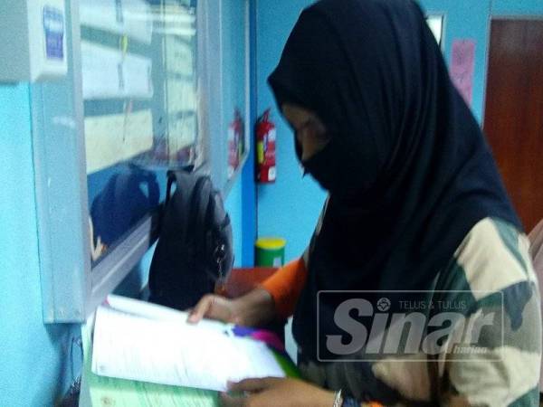Siti Zahida terharu melihat surat beranak berstatus warganegara yang diperolehi anak-anaknya.