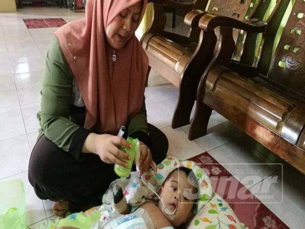 Zuraidah memberikan susu kepada Rezfan menggunakan tiub.