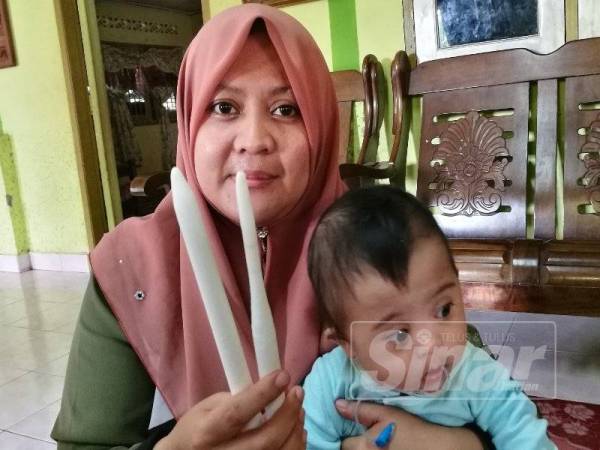 Zuraidah menunjukkan lilin yang digunakan untuk menjolok lubang dubur anaknya.
