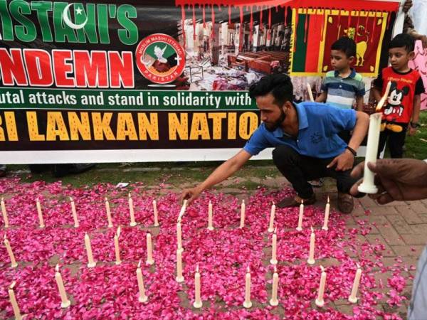 Penduduk menyalakan lilin sebagai tanda memperingati mangsa serangan berdarah di Sri Lanka pada Ahad lalu.