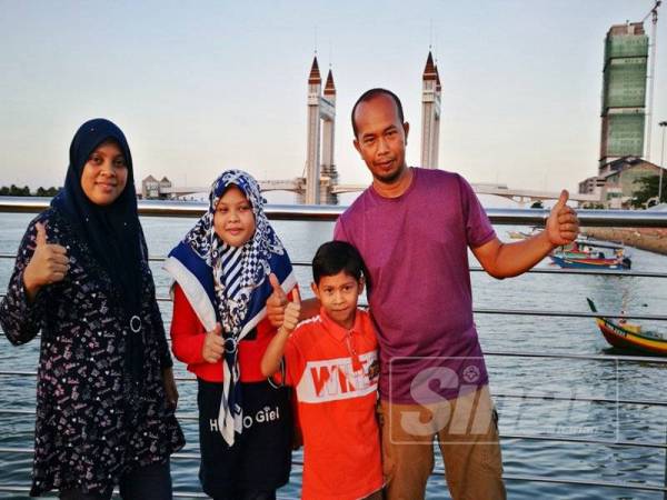 Tuan Muazizan (kiri) bersama suami dan anak-anaknya kali pertama berkunjung ke Pesisir Payang dan mengambil peluang merakam gambar berlatar belakang jambatan angkat Kuala Terengganu.