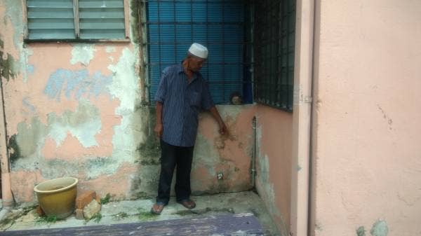 Azizan melihat keretakan yang berlaku di Pangsapuri Taman Keramat Permai, di sini, tadi.