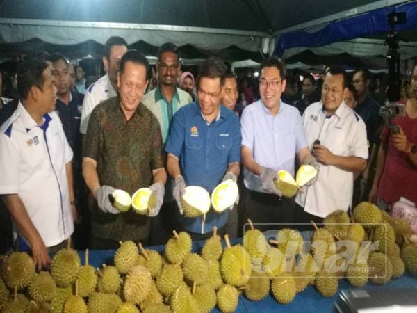 Saifuddin (tiga dari kanan) menunjukkan durian yang dihidangkan secara percuma kepada orang ramai sempena Kempen Beli Barangan Buatan Malaysia yang diadakan malam tadi.