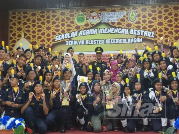Nazli (tengah) bersama pelajar Sekolah Agama Menengah Bestari Subang Jaya dan Sekolah Menengah Kebangsaan Pasir Gudang, Johor yang menjuarai pertandingan kawad kaki kadet JPJ peringkat kebangsaan, semalam. 