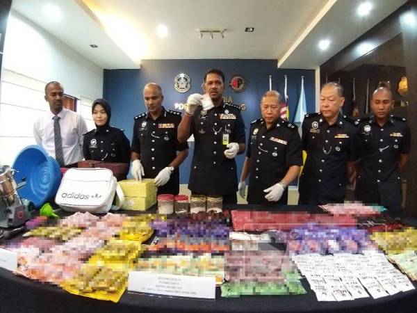 Narenasagaran (tengah) menunjukkan dadah yang dirampas dari sindiket berkenaan.
