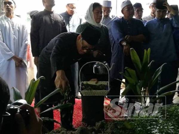 Ahmad Faizal menyiram air mawar di pusara bondanya.