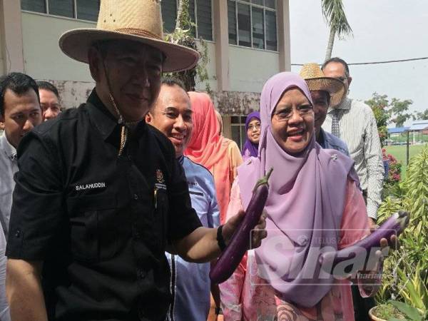 Salahuddin menunjukkan terung hasil tanaman pelajar menerusi program "My Green Team" di SMK Dato Penggawa Barat, di sini hari ini.