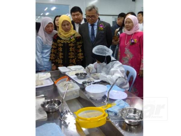 Mohd Redzuan (tengah) melihat proses produk sarang burung walit.