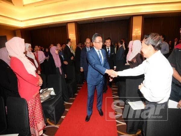 Adly Zahari (tengah) bersalaman dengan peserta Seminar Melaka Beribawa, Harapan dan Cabaran Pembangunan Untuk Semua di sebuah hotel di Banda Hilir, hari ini.