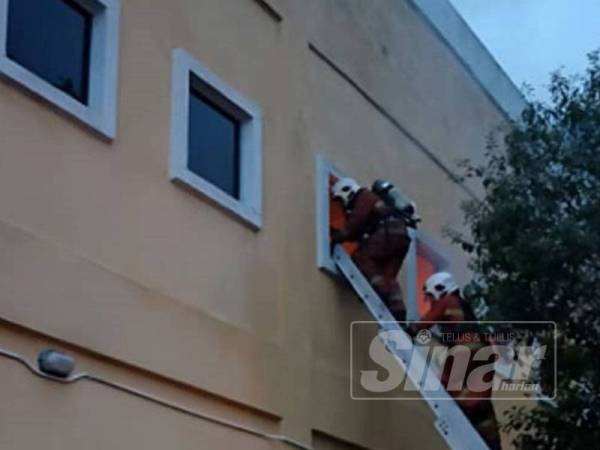 Anggota bomba melakukan kerja pemadaman api di bangunan yang terbakar.
