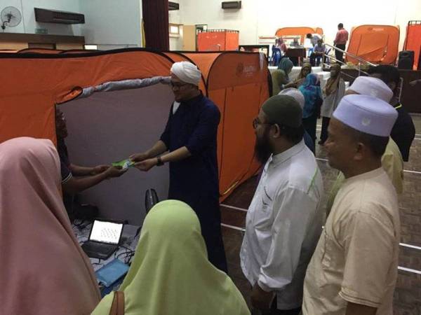 Ahli Pas Gombak menziarahi penduduk yang terlibat kejadian keretakan Flat Taman Keramat Permai di pusat pemindahan sementara di Dewan AU2, Hulu Kelang, semalam. - FOTO FACEBOOK PAS GOMBAK
