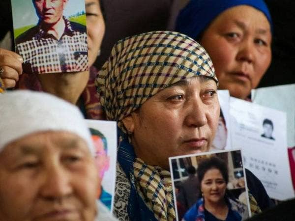 Penduduk Uighur memegang gambar ahli keluarga mereka yang hilang dan dipercayai ditahan di ‘kem pendidikan semula’.