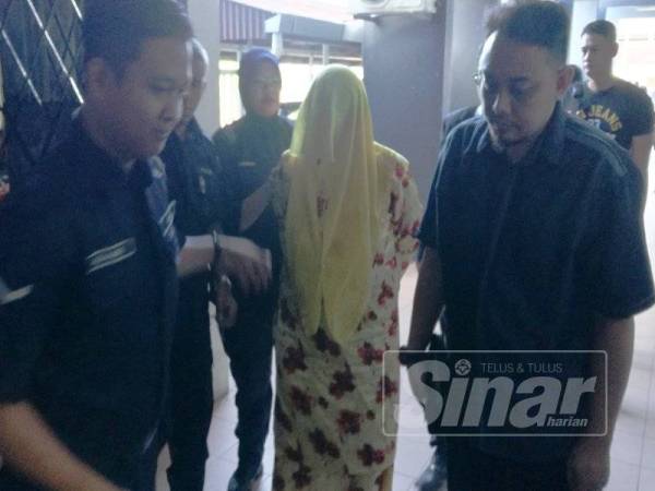 Anggota polis membawa tertuduh ke Mahkamah Sesyen Ipoh hari ini.