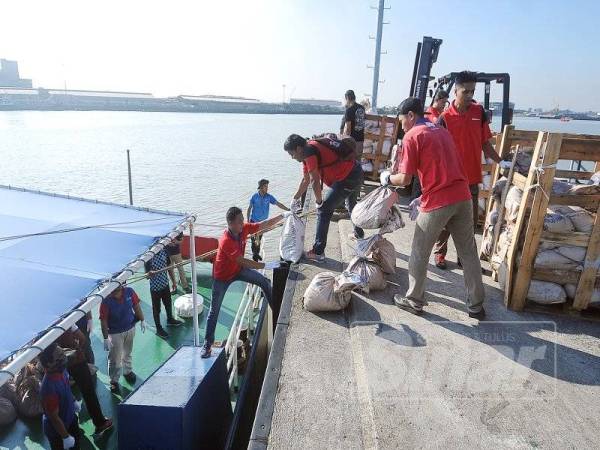 Staf Kumpulan Media Karangkraf melakukan proses pemunggahan abu al-Quran ke atas kapal KPD Setia di jeti Markas Operasi Pasukan Polis Marin Selangor. - Foto Sinar oleh ROSLI TALIB 