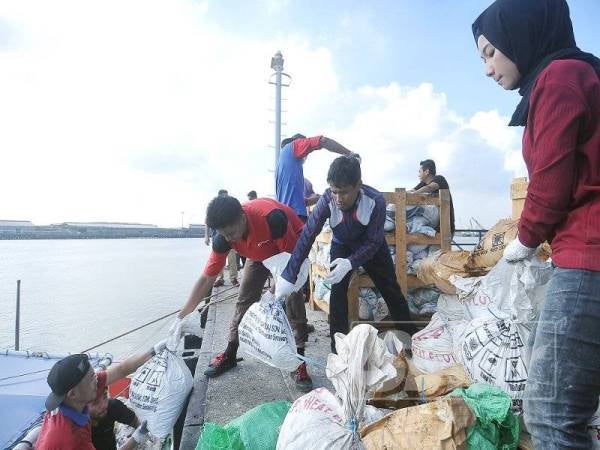 Staf Kumpulan Media Karangkraf melakukan proses pemunggahan abu al-Quran ke atas kapal KPD Setia di jeti Markas Operasi Pasukan Polis Marin Selangor. - Foto Sinar oleh ROSLI TALIB 