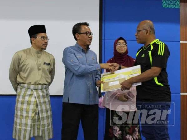 Zailani (kanan) menerima replika cek yang disampaikan Mohd Sofi dan diperhatikan Fadhilah (dua dari kanan) dan Md Azhan (kiri) pada majlis penyerahan itu.