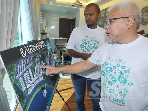 Hussamuddin bersama Mohd Fadzil ketika melawat unit rumah contoh. - FOTO ROSLI TALIB