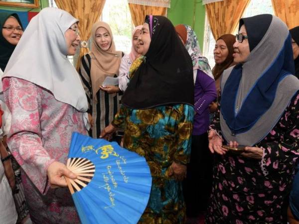 Dr Wan Azizah (kiri), yang juga Pengerusi Majlis Penasihat PKR, beramah mesra dengan warga emas dan ibu tunggal ketika melawat Kampung Melayu Bumiputera Sim-Sim, iaitu sebuah perkampungan di atas air sempena kempen bagi PRK Parlimen Sandakan hari ini. -Foto Bernama