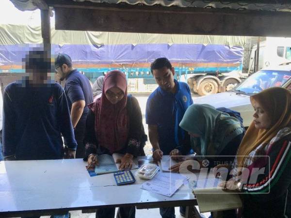 Seorang lelaki (kiri) terkejut apabila diserbu penguatkuasa JAIM ketika sedang membeli makanan di sebuah warung di Bukit Rambai.