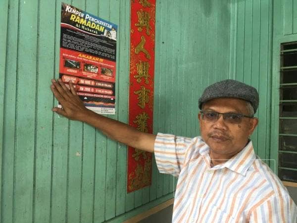 Ketua Pegawai Penguatkuasa JAIM, Datuk Rahimin Bani menampal poster penghayatan Ramadan di sebuah premis makanan di Tanjung Kling.
