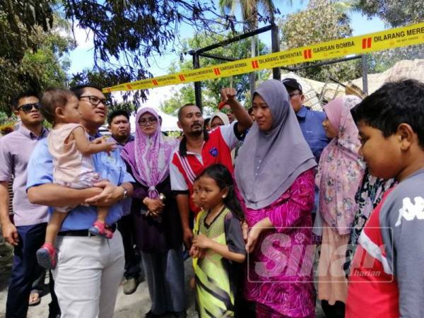 Ahmad Faizal (kiri) ketika menemui keluarga mangsa.
