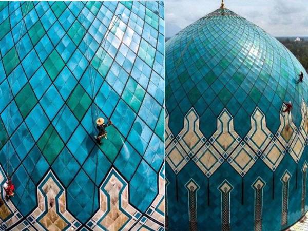  Dua petugas sedang membersihkan kubah masjid Jamek Negeri Sarawak, Petra Jaya, Kuching. - Foto Bernama