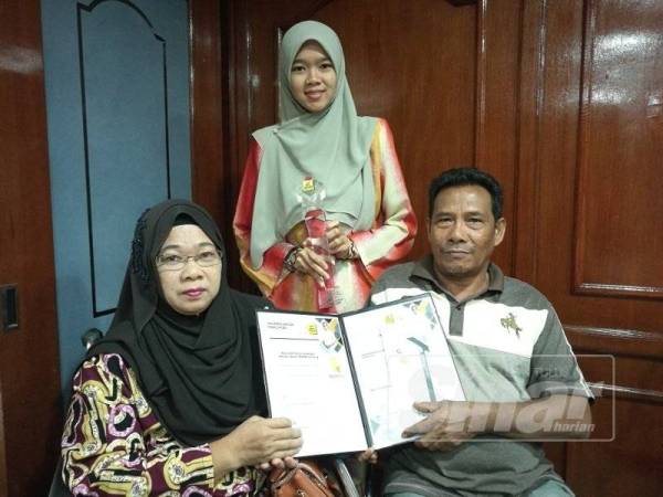 Nur Aqilah Atikah bersama ayah, Mat Sarif Arof, 55 dan ibunya, Norlin Zarena Abdullah, 55 menunjukkan plak dan sijil penghargaan sempena biasiswa BKMB yang diterimanya di Wisma Pahang di sini hari ini.