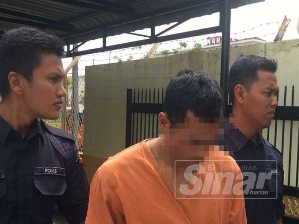 Suspek (tengah) ketika dibawa keluar dari Mahkamah Majistret Tanah Merah.
