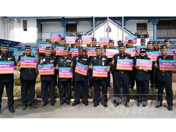 Aidi (tengah) bersama warga PDRM Terengganu memegang placard kempen World#QuranHour bagi menjayakan program itu yang akan diadakan serentak pada 30 Mei ini.