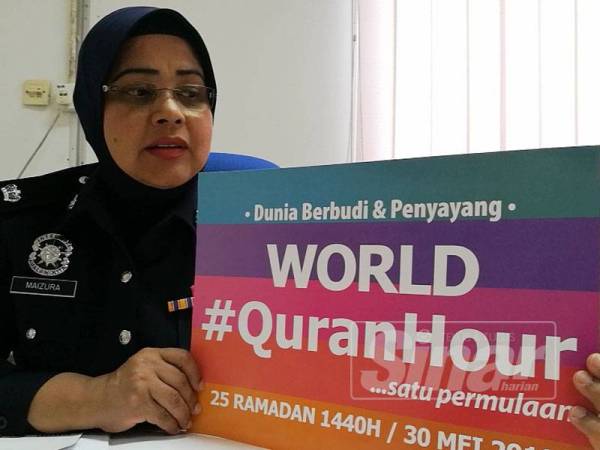 Maizura memegang placard kempen World#QuranHour ketika ditemui di pejabatnya di IPK Terengganu.