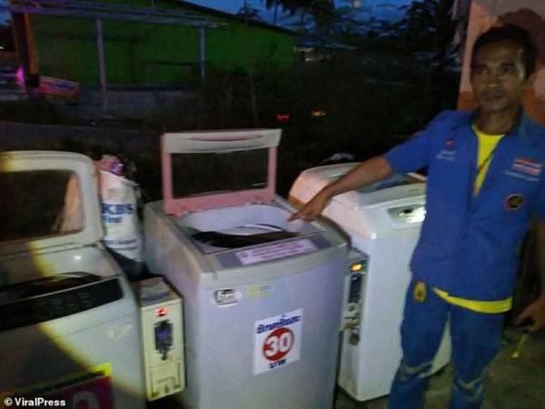 Anggota penyelamat menunjukkan mesin basuh di mana bayi itu ditemukan.