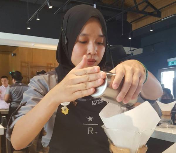 Pengurus Stor Starbucks Setia Alam, Nor Asyikin Shahar sedang membru kopi.