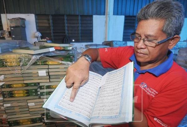 Muhamad Azmi menunjukkan kesilapan pada al-Quran yang menyebabkan ia terpaksa dilupuskan.
