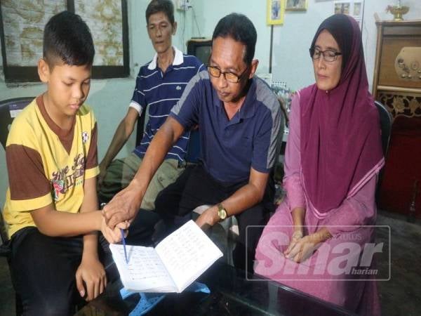 Aziz (dua,kanan) mengajar Mohd Firdaus membaca Iqra sambil diperhatikan Hun Kheng.