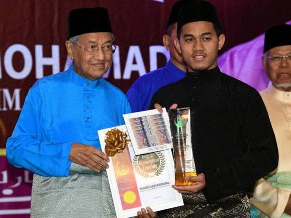 Dr Mahathir merangkap Yang Dipertua Perkim menyampaikan Anugerah Kepimpinan Cemerlang Kelab Perkim Universiti kepada Muhammad Sabhan Iman Ismail dari Universiti Islam Antarabangsa Malaysia pada majlis iftar hari ini. -Foto Bernama