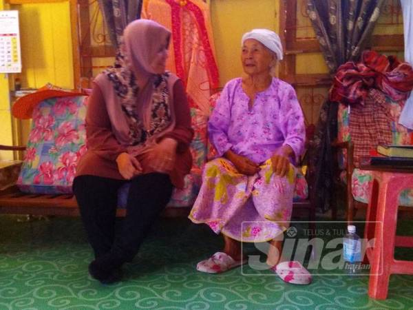 Mas Ermieyati (kiri) ketika menyantuni Limah pada Ziarah Kasih di Kampung Paya Lebar, Masjid Tanah.