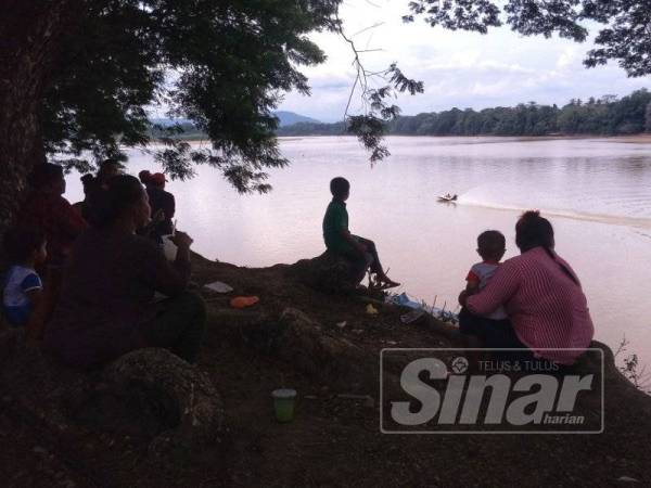 Orang ramai tidak melepaskan peluang menyaksikan pertandingan bot laju sambil berkelah di tepi sungai.
