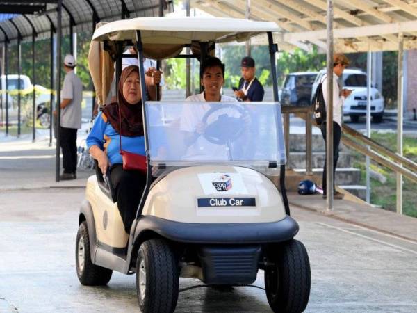 Petugas Suruhanjaya Pilihan Raya (SPR) menggunakan buggy untuk membawa pengundi kurang upaya dan warga emas ke pusat mengundi sempena Pilihan Raya Kecil Parlimen (PRK) Sandakan di Pusat Mengundi Sekolah Kebangsaan Muhibbah hari ini. - Foto Bernama