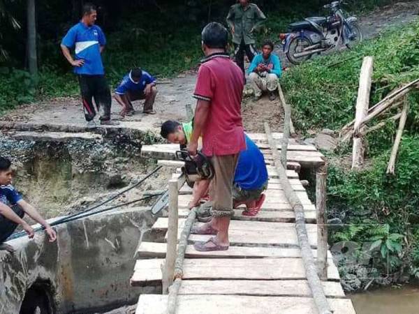 Penduduk Kampung Air Kelat, Gerik terpaksa membina titi sementara menggunakan batang pinang dan kayu bagi memudahkan penduduk menaiki motosikal melaluinya.