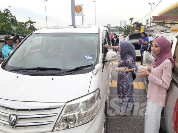 Serahan bubur lambuk turut disampaikan oleh personaliti RTM kepada orang ramai.