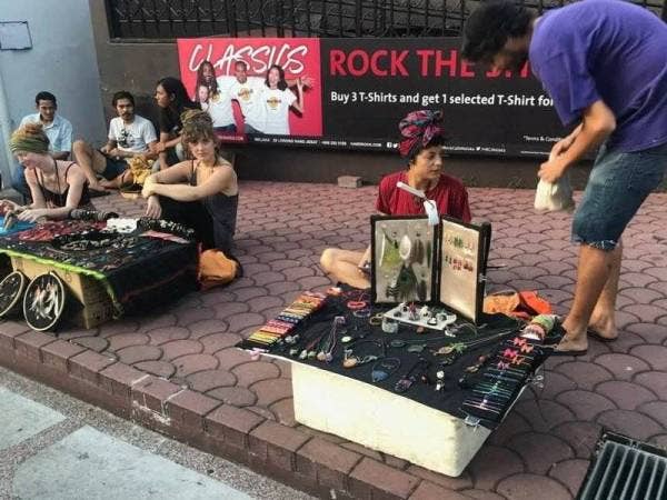 Gambar yang dimuat naik pengguna Facebook mengenai sekumpulan pelancong asing didapati menjaja barangan kraftangan di siar kaki Jonker Street di Banda Hilir, di sini, semalam.