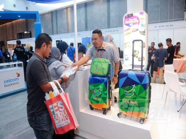 Pengurus Besar Glocal Travel, Ezuan Azizi Md. Arith memberikan penerangan kepada pengunjung di Festival Guru Malaysia 2019 di sini hari ini.