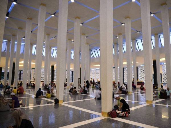 Para jemaah wanita sabar menunggu giliran untuk mengambil hidangan nasi beriani yang disediakan selepas selesai menunaikan solat Maghrib di Masjid Negara. Sempena Ramadan, pihak pengurusan Masjid Negara memperuntukan juadah berbuka puasa secara percuma untuk 1,500 jemaah setiap hari sepanjang bulan ini. Foto: Bernama