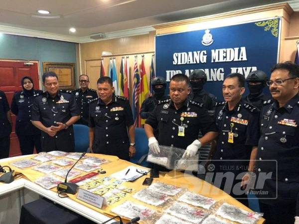 Kamarulzaman (tengah) menunjukkan dadah yang dirampas dalam serbuan di sebuah hotel di Pandan Indah, Ampang Jaya, semalam.